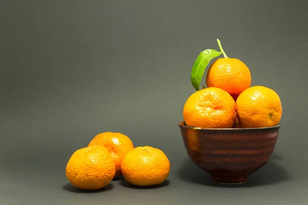 Натюрморт со свежими мандаринами в красной чаше — стоковое фото