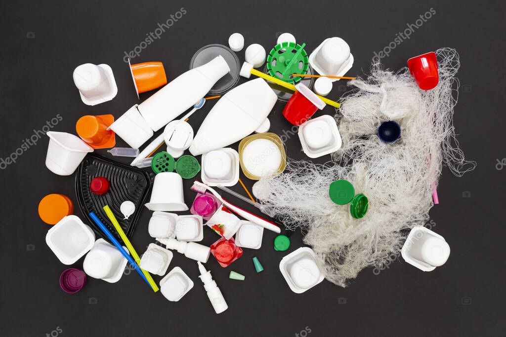 Assortment of obsolete plastic garbage items on black background