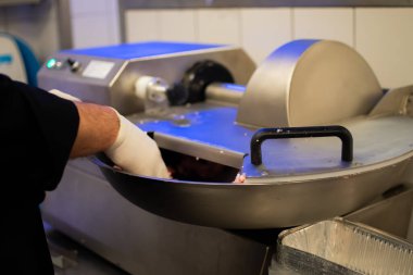 Aşçı, öğütücüde köfte kompozisyonu hazırlıyor.