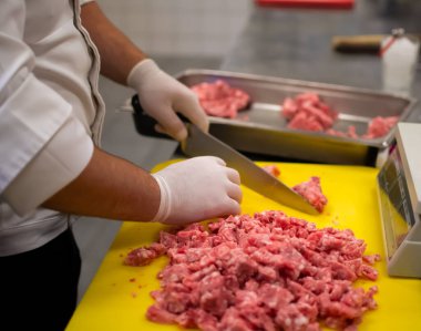 Aşçı, öğütücüde köfte kompozisyonu hazırlıyor.