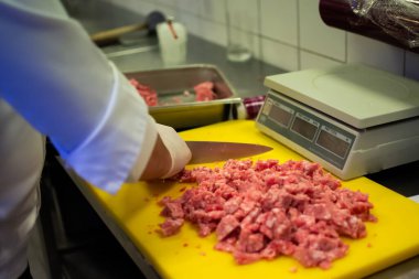 Aşçı, öğütücüde köfte kompozisyonu hazırlıyor.