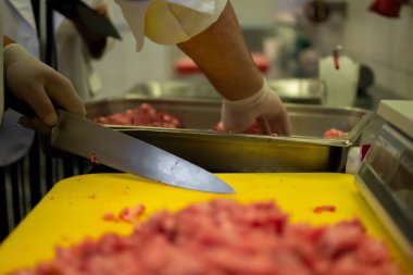 Aşçı, öğütücüde köfte kompozisyonu hazırlıyor.