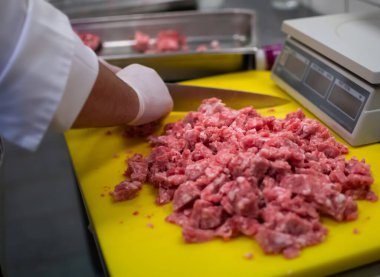 Aşçı, öğütücüde köfte kompozisyonu hazırlıyor.