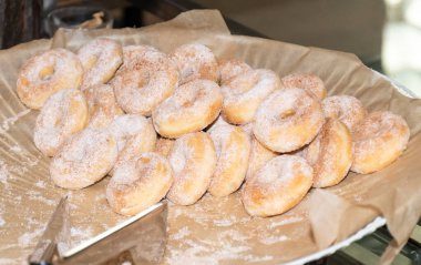 Kahvaltıda ya da catering etkinliğinde tabakta taze ve tatlı pudra şekerli yuvarlak çörekler. Hamur tatlısı ev yapımı ve lezzetli kahvaltılık aperatif