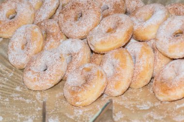 Kahvaltıda ya da catering etkinliğinde tabakta taze ve tatlı pudra şekerli yuvarlak çörekler. Hamur tatlısı ev yapımı ve lezzetli kahvaltılık aperatif