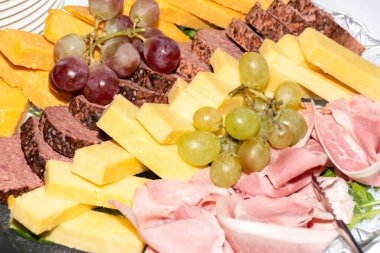 Taze kesilmiş antipasto seçimi: brunch, kahvaltı, ziyafet ya da catering etkinliği sırasında cam tabakta sunulan şarap için jambon, peynir, kurutulmuş domates ve et aperatifleri. Bir sürü taze kanepe.