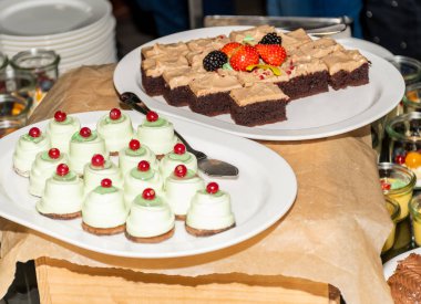 Lezzetli hazır kahvaltı büfesi çikolatalı haşhaş tohumları ve beyaz tabakta badem ezmesi tatlısı. Otel, yemek servisi, lüks etkinlik ya da kutlama. Yemek servisi.