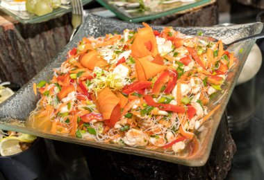 Kırmızı, portakal, deniz ürünleri, maydanoz ve salata yapraklı sarı biber, pirinç eriştesi. Brunch büfesi ya da yemek şirketi özel etkinliği sırasında geleneksel Asya yemekleri..