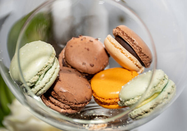 Many different colored macaroons in a festive Christmas transparent globe hanging in a festive decoration during brunch or catering event