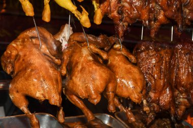 Restoranın mutfağında rafta asılı duran kızarmış ördekler.