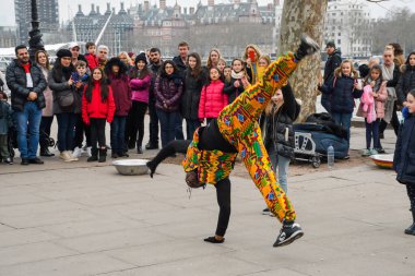 Londra, Birleşik Krallık, 24 Ocak 2020: Brezilyalı akrobatik dansçılar Londra yakınlarındaki bir sokakta, nehir kenarında Thames nehrinde, kalabalıkla alkış tutuyorlar.