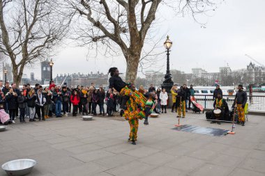 Londra, Birleşik Krallık, 24 Ocak 2020: Brezilyalı akrobatik dansçılar Londra yakınlarındaki bir sokakta, nehir kenarında Thames nehrinde, kalabalıkla alkış tutuyorlar.