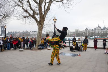 Londra, Birleşik Krallık, 24 Ocak 2020: Brezilyalı akrobatik dansçılar Londra yakınlarındaki bir sokakta, nehir kenarında Thames nehrinde, kalabalıkla alkış tutuyorlar.