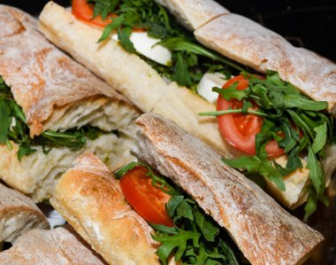 Açık hava festivalinde sandviçler sergileniyor. Yemek servisi dışında. Yemek Büfesi Yemek Yeme Partisi Paylaşım Konsepti. Et, pastırma, peynir ve salata. Taze çörek sandviçler, yemeye hazır.