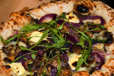 Taze fırın geleneksel prosciutto, roka, domates ve parmesan pizza, ahşap bir tahtanın üzerinde servis edilir.