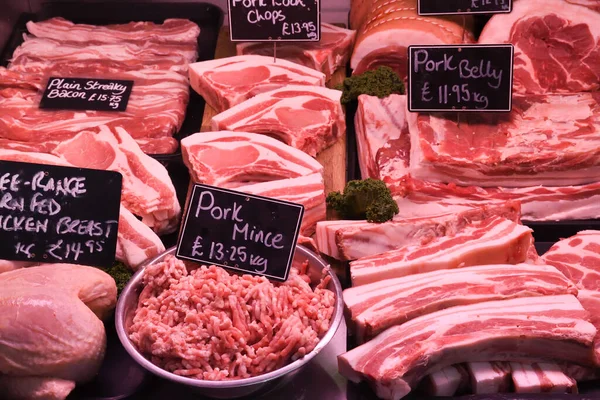 Various Meat cuts exposed in the butchery fridge counter. Raw meat in assortment in a butcher shop