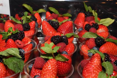 İtalya 'da satılık plastik bardakta taze toplanmış çilekler. Satılık çilekler, sokak yiyecekleri pazarı. Taze gıda pazarı. Satılık kırmızı çilek yığını, sağlıklı..