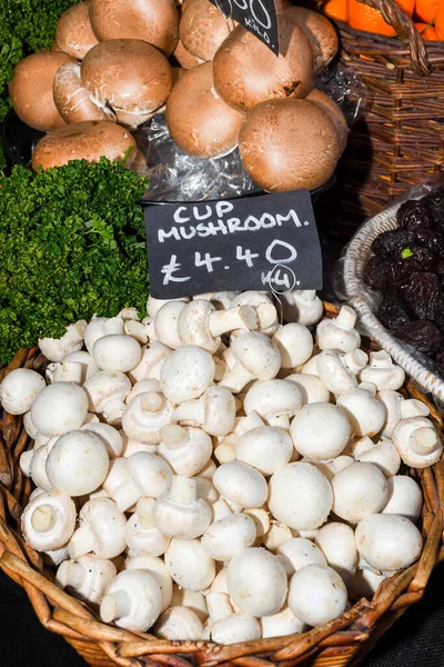 Mushrooms for sale. Local autumn produce for sale displayed at the market. Borough farmer's market in London. Organic and bio fresh healthy eating concept. Veggies, vegetables, hers and spices