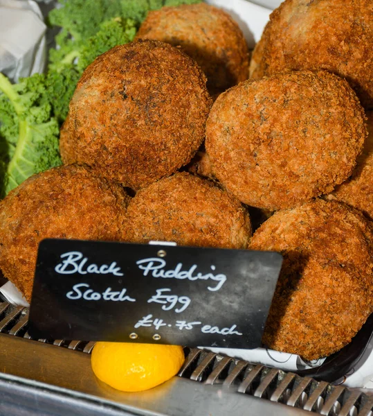 Black pudding Scotch egg. A Scotch egg consists of a whole soft or hard-boiled egg wrapped in sausage meat, coated in bread crumbs and baked or deep-fried.