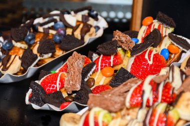 Sokak yemekleri: Waffle 'lar ve çeşitli malzemelerle küçük krepler ve meyveler. Taze Yemek Büfesi Yemek Yemeği Paylaşım Partisi Konsepti