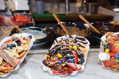 Sokak yemekleri: Waffle 'lar ve çeşitli malzemelerle küçük krepler ve meyveler. Taze Yemek Büfesi Yemek Yemeği Paylaşım Partisi Konsepti