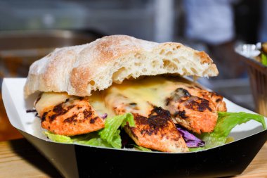 Fast food festivalinde yenmeye hazır taze erimiş hamburger. Açık hava yemek organizasyonu, brunch ya da fast food ile akşam yemeği partisi. Erimiş peynir ve altın çörek. İştah açıcı ev yapımı hamburger.