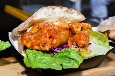 Fast food festivalinde yenmeye hazır taze erimiş hamburger. Açık hava yemek organizasyonu, brunch ya da fast food ile akşam yemeği partisi. Erimiş peynir ve altın çörek. İştah açıcı ev yapımı hamburger.