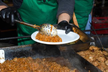 Sağlıksız, yağlı, yağlı, et dilimleri karışımı, fast food festivalinde büyük bir tencerede kızarma. Geleneksel Romanya yemeği olan 