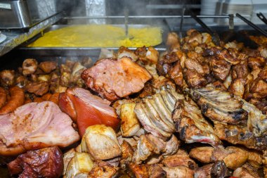 Sağlıksız, yağlı, yağlı, et dilimleri karışımı, fast food festivalinde büyük bir tencerede kızarma. Geleneksel Romanya yemeği olan 