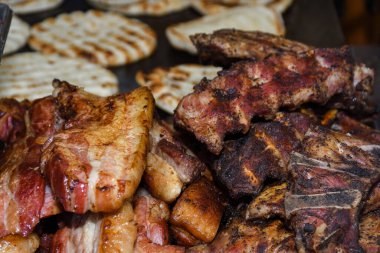 Sağlıksız, yağlı, yağlı, et dilimleri karışımı, fast food festivalinde büyük bir tencerede kızarma. Geleneksel Romanya yemeği olan 