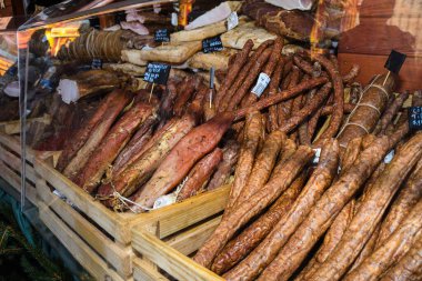 Çeşitli et ürünleri, sosisler, sucuk, karanlık bir masada baharatlar. Yukarıdan bak. Farklı baharatlı baharatlı sığır eti ve domuz sosisi çeşitleri. Sokak yemekleri, fast food çeşitleri.