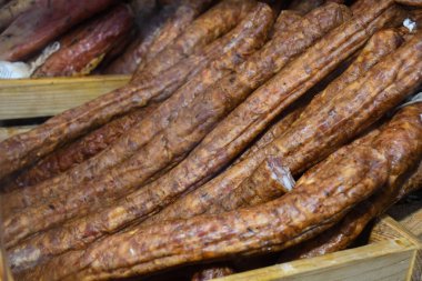 Çeşitli et ürünleri, sosisler, sucuk, karanlık bir masada baharatlar. Yukarıdan bak. Farklı baharatlı baharatlı sığır eti ve domuz sosisi çeşitleri. Sokak yemekleri, fast food çeşitleri.