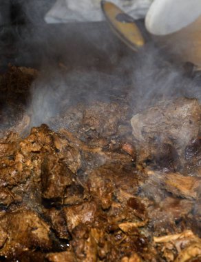 Sağlıksız, yağlı, yağlı, et dilimleri karışımı, fast food festivalinde büyük bir tencerede kızarma. Geleneksel Romanya yemeği olan 