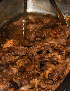 Sağlıksız, yağlı, yağlı, et dilimleri karışımı, fast food festivalinde büyük bir tencerede kızarma. Geleneksel Romanya yemeği olan 