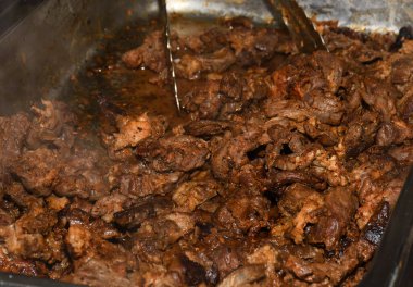 Sağlıksız, yağlı, yağlı, et dilimleri karışımı, fast food festivalinde büyük bir tencerede kızarma. Geleneksel Romanya yemeği olan 