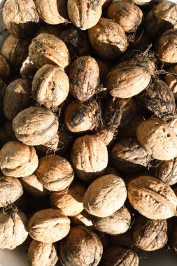 Bir sürü organik kase ve bir yığın ceviz, şarküteride satılıyor. Pazar yeri, yaz veya sonbahar aylarında güneşte işlenmemiş ürünler. Makro ya da detay çekimi, yukarıdan görünüm.