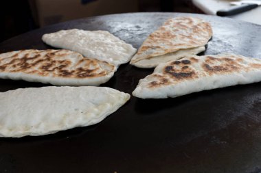 Et veya peynirle doldurulmuş ve levha demirinde pişirilmiş düz ekmekten yapılmış olan ve bir sokak gıda pazarında satışa sunulan geleneksel Türk yemeği Gözleme. Türkiye 'de hamur işi uzmanlığı