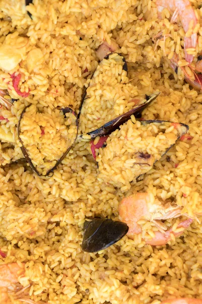 Seafood paella cooked in a large pan wok, street food festival. Mexican fiesta national day dish specialty. Live cooking station. Fresh Food Buffet Brunch Catering Dining Eating Party Sharing Concept