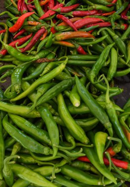 Gıda festivali pazarında tezgahın üstünde yeşil ve kırmızı biber. Taze ve çiğ yeşil biber yığını, birçok yemek için otantik baharatlı Meksika malzemesi. Satılık ürünler