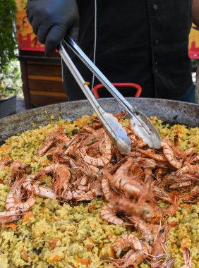 Deniz ürünleri paella 'sı büyük bir tavada pişmiş, sokak yemeği festivali. Meksika Fiesta Ulusal Yemek Günü spesiyali. Canlı yemek istasyonu. Taze Yemek Büfesi Yemek Yemeği Paylaşım Partisi Konsepti