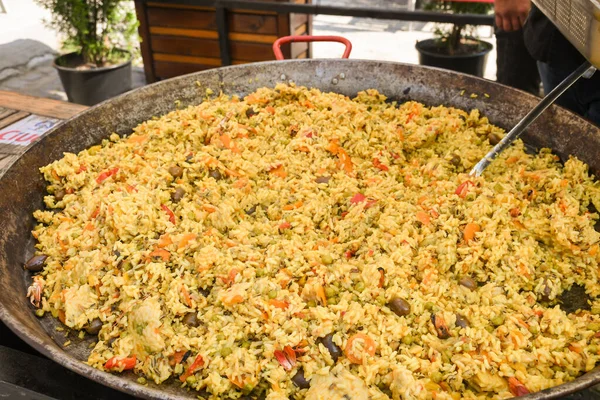 Seafood paella cooked in a large pan wok, street food festival. Mexican fiesta national day dish specialty. Live cooking station. Fresh Food Buffet Brunch Catering Dining Eating Party Sharing Concept