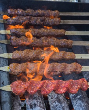 Adana kebabı (mangal kömürü üzerine ızgara üzerinde kıymalı et). Şef geleneksel otantik Türk shaworması hazırlıyor. Ortadoğu mutfağı. Baharatlı el yapımı sokak yemekleri.