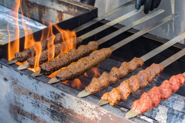 Adana kebabı (mangal kömürü üzerine ızgara üzerinde kıymalı et). Şef geleneksel otantik Türk shaworması hazırlıyor. Ortadoğu mutfağı. Baharatlı el yapımı sokak yemekleri.
