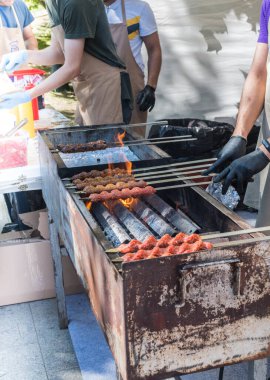 Adana kebabı (mangal kömürü üzerine ızgara üzerinde kıymalı et). Şef geleneksel otantik Türk shaworması hazırlıyor. Ortadoğu mutfağı. Baharatlı el yapımı sokak yemekleri.