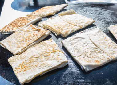 Et veya peynirle doldurulmuş ve levha demirinde pişirilmiş düz ekmekten yapılmış olan ve bir sokak gıda pazarında satışa sunulan geleneksel Türk yemeği Gözleme. Türkiye 'de hamur işi uzmanlığı