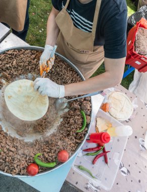 Geleneksel Türk shawarma eti kırmızı domatesler ve kırmızı ve yeşil biberlerle hazırlanıyor.