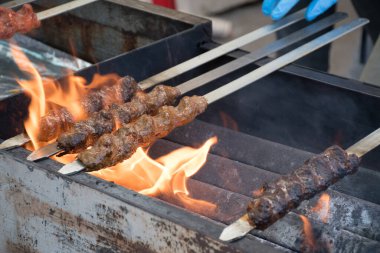 Adana kebabı (mangal kömürü üzerine ızgara üzerinde kıymalı et). Şef geleneksel otantik Türk shaworması hazırlıyor. Ortadoğu mutfağı. Baharatlı el yapımı sokak yemekleri.