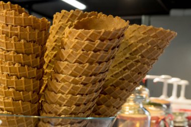 Fast food festivali sırasında şekerci dükkanında çıtır çıtır altın renkli boş dondurma külahları. Tatlı ikram, glütensiz, laktozsuz, şekersiz, biyolojik ve organik ürün.