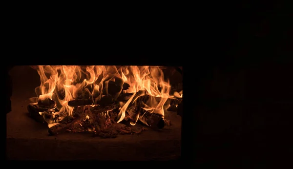 Fire and burn coals in stone oven. Oven made of brick and clay on the wood. Oven for pizza. Brick oven. big burning flames isolated on black, copy space