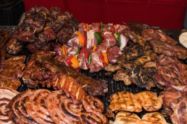 Şef ızgarada et hazırlıyor, dışarıda yemek festivali, yemek kamyonu, brunch ya da catering etkinliği sırasında. Domuz bifteği, tavuk göğsü, sosis, yüksek protein, sağlıksız ve şişman et parçaları.